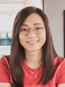 Headshot of a woman wearing glasses and a red short sleeve shirt and a gold necklace
