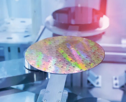 A semiconductor wafer sitting on a pedestal inside a machine with another wafer in the background